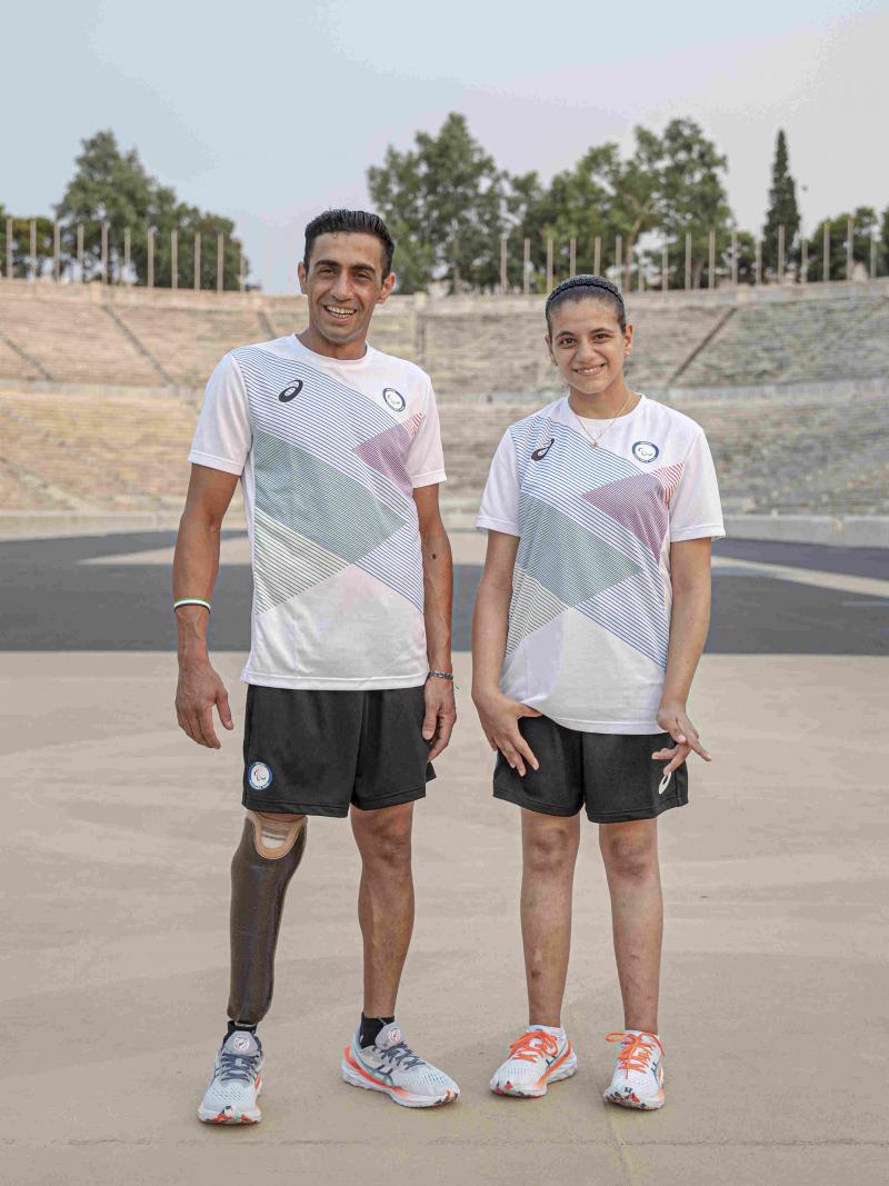Man and woman stand next to each other with Asics gear