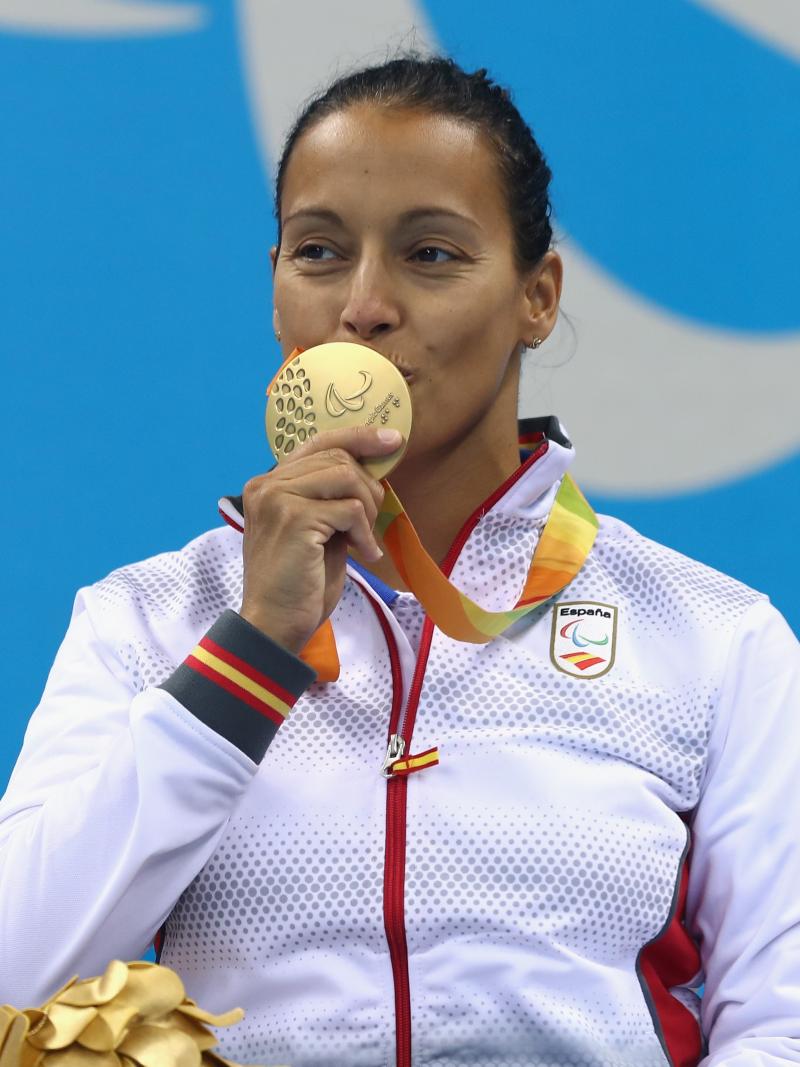 A woman kissing her gold medal