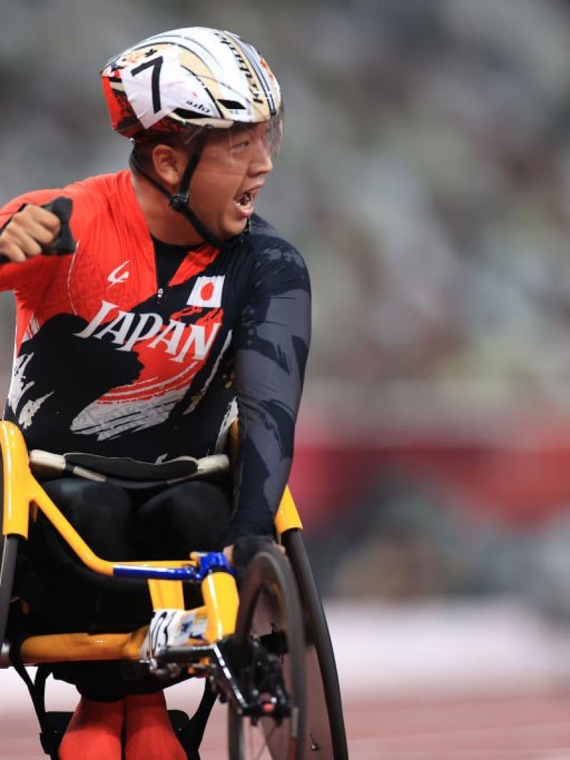A man in a wheelchair celebrates the victory, putting his fist up