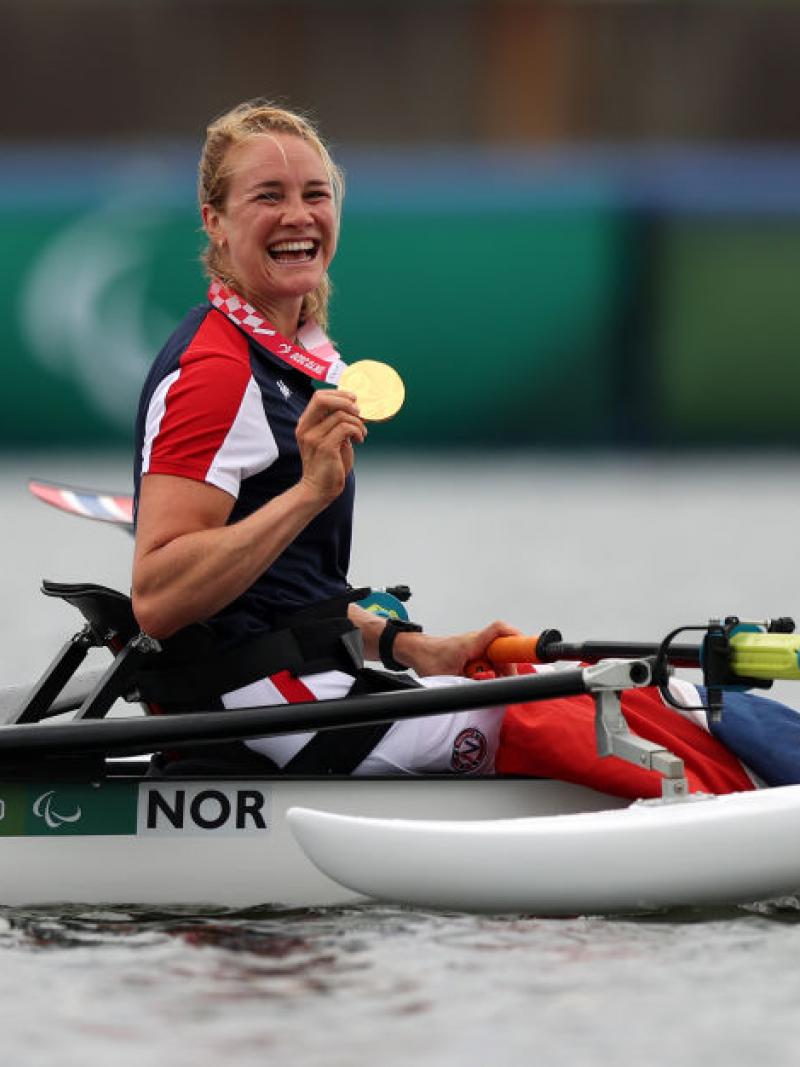 Female rower on her boat celebrates gold medal