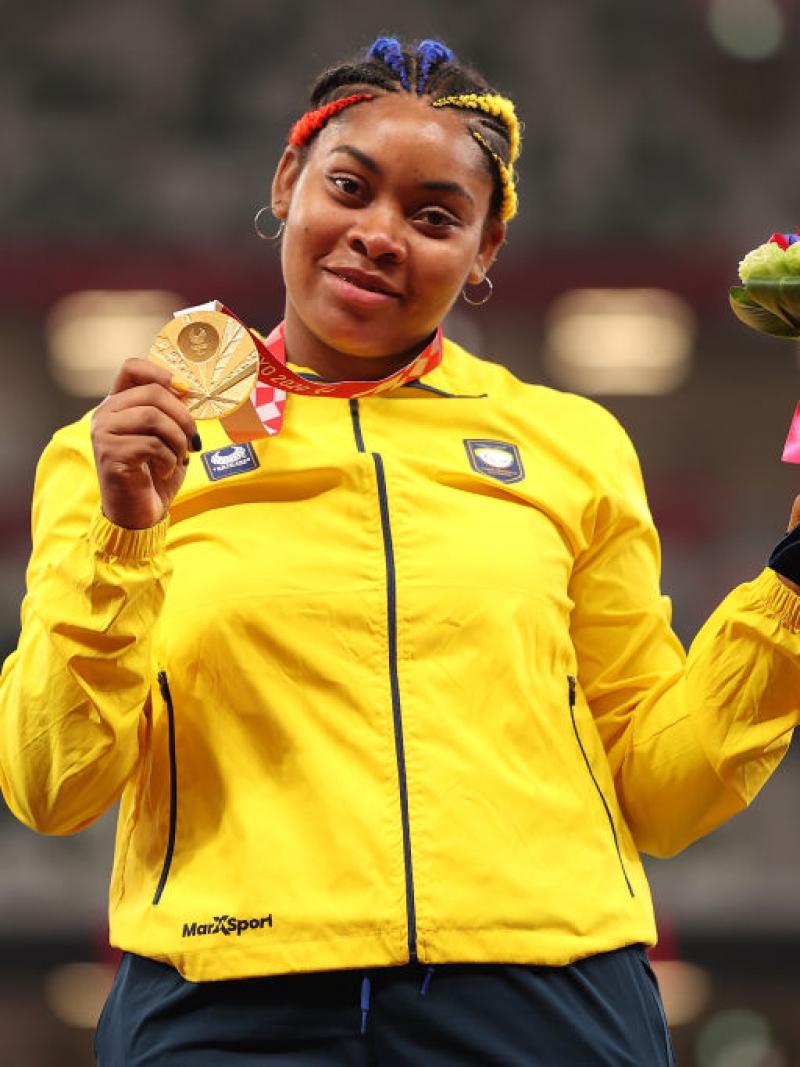Woman smiles with gold medal around neck