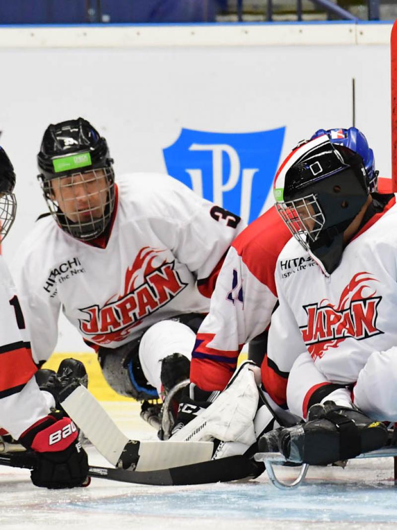 Para ice hockey players trying to find the puck on the ice