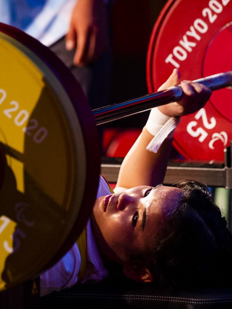 A woman on a bench press ready to lift a bar