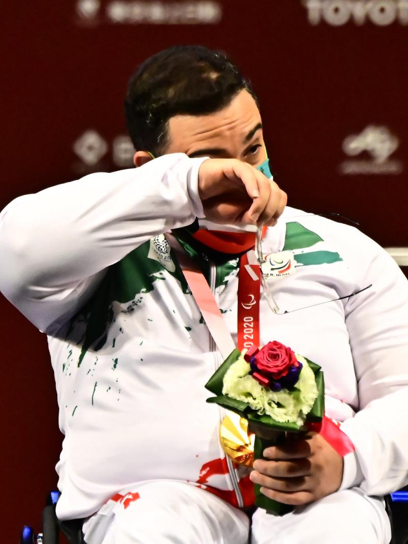 A man crying with a gold medal around his neck