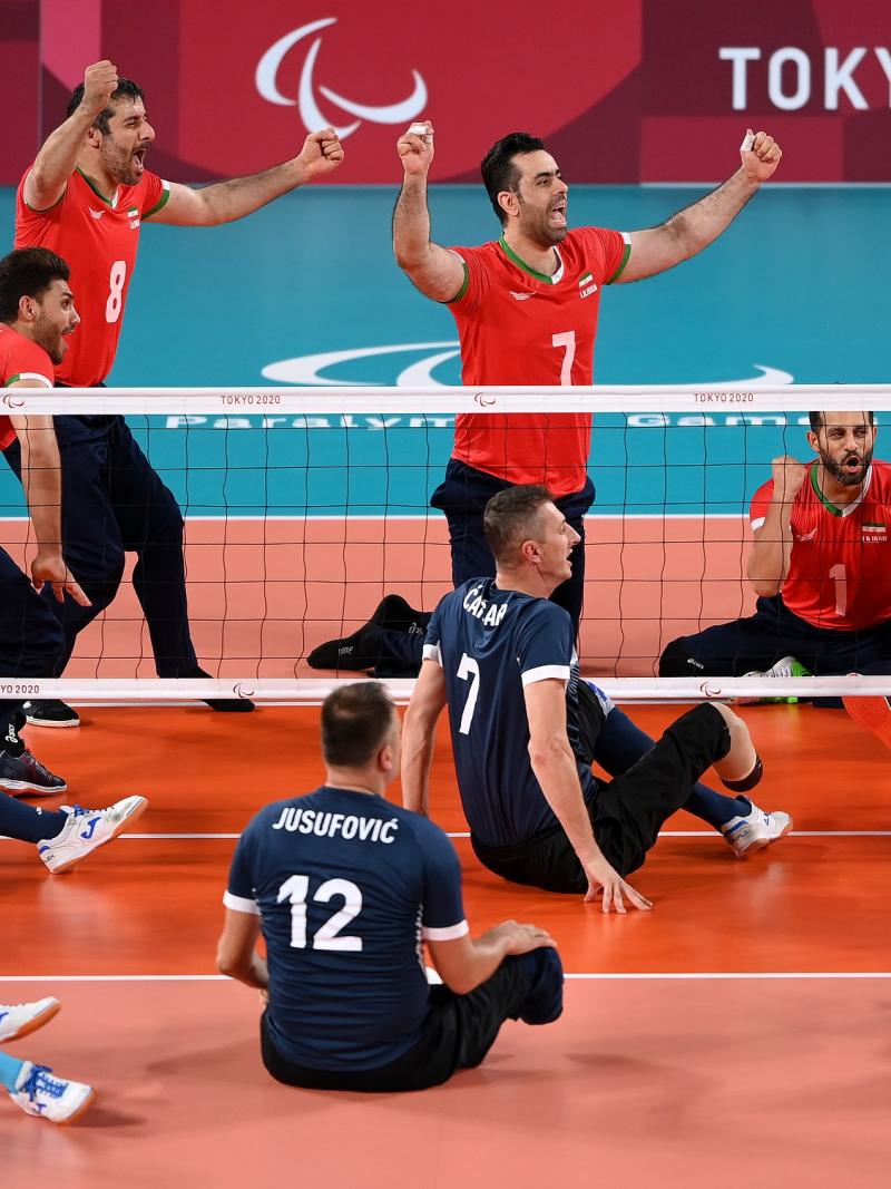 Iranian sitting volleyball team celebrates while Bosnian remains shocked on the other side of the net