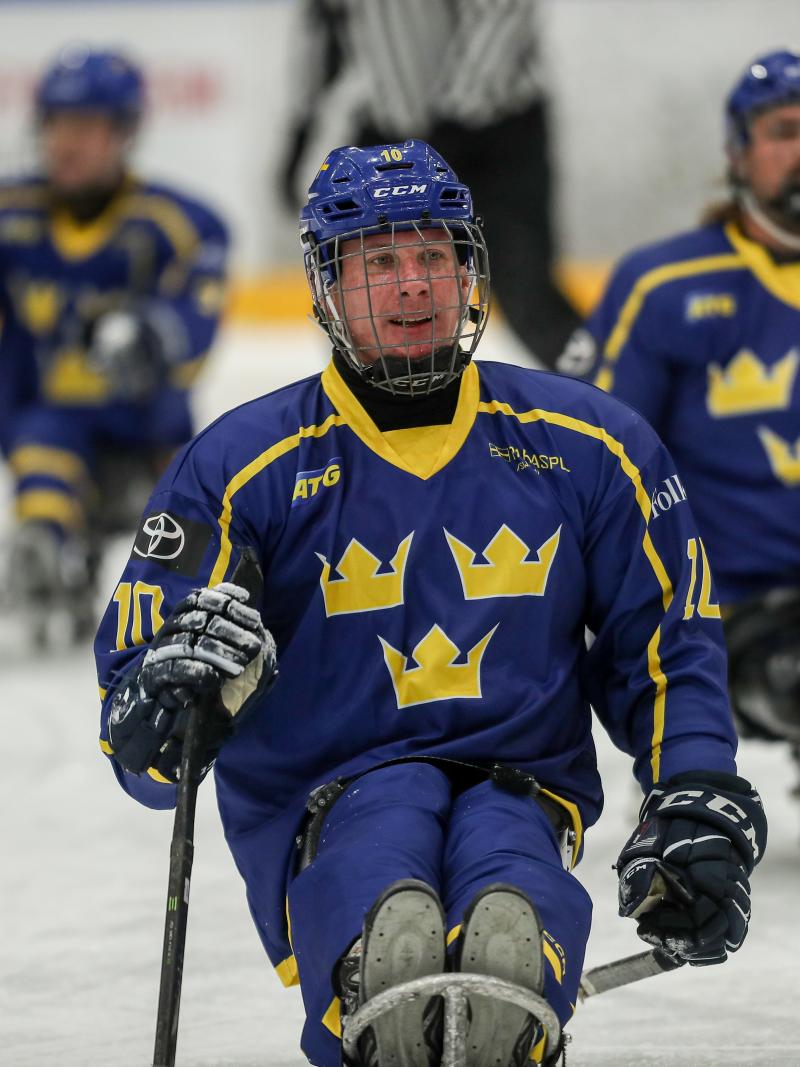 A man skating on a sled and smiling