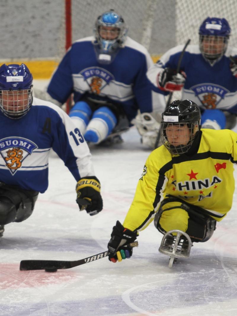 Men chasing the puck on a sled