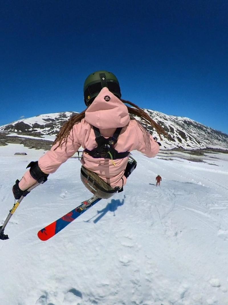 A female sit-skier seen from behind in a freestyle slope