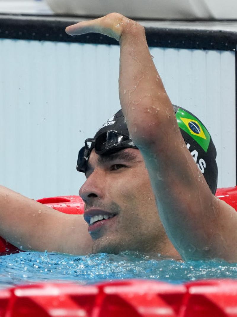 A handless swimmer waving from inside the pool