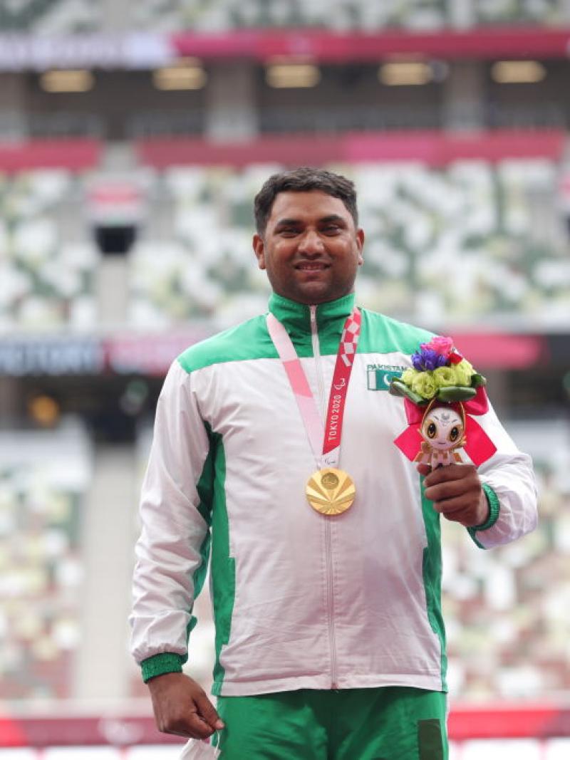 A man with a gold medal in a stadium 