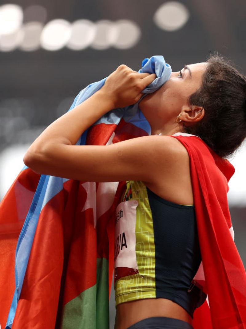 A female Para athletics athlete holding the flag of Azerbaijan