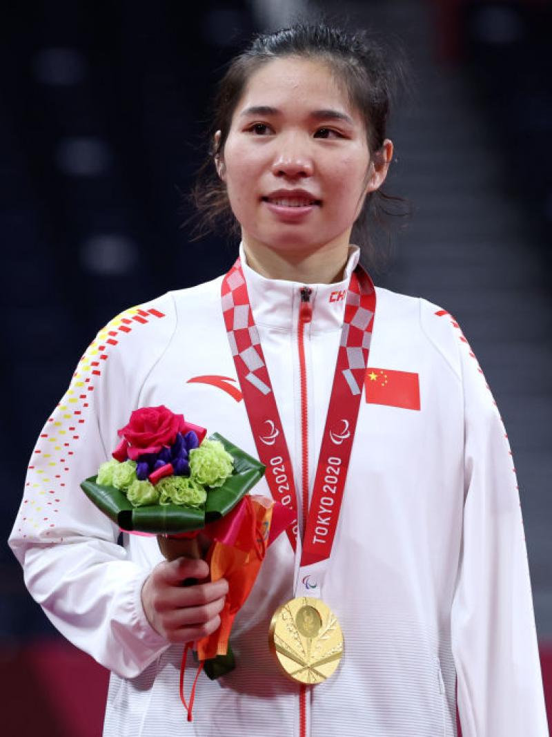 Yang Qiuxia on the podium with gold medal and flowers