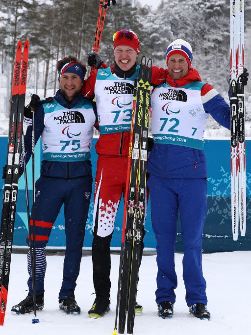 Three men standing on the snow with their skies 