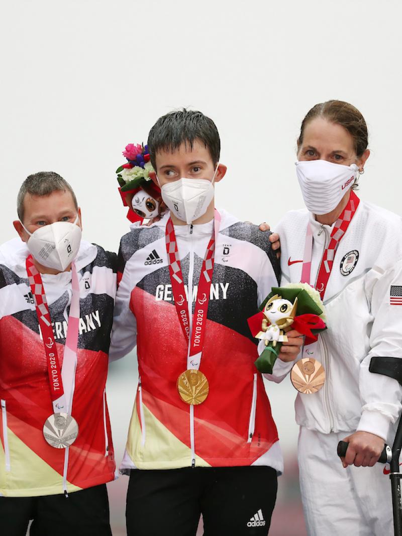 Three women on podium with medals