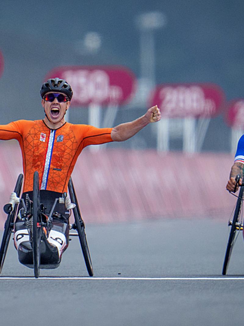 Man celebrates in handbike as opponent disappointed 