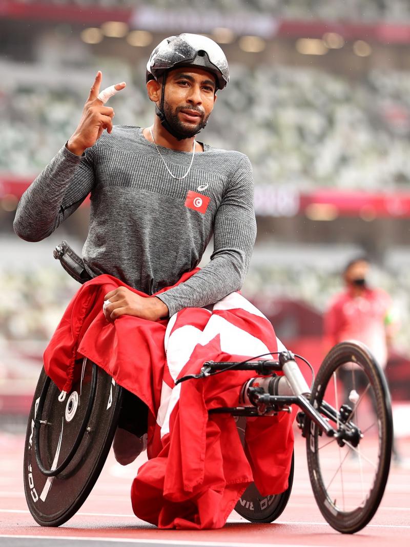 Wheelchair racer Walid Ktila celebrates with the Tunisian flag after winning the 800m 