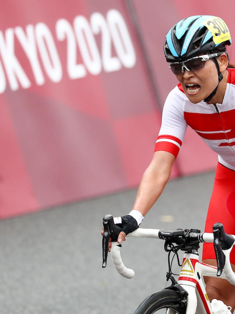 Japanese female cyclist celebrates on her bike
