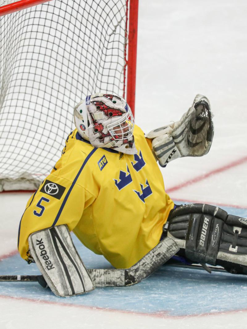 A Para ice hockey goalie holding a puck in his glove
