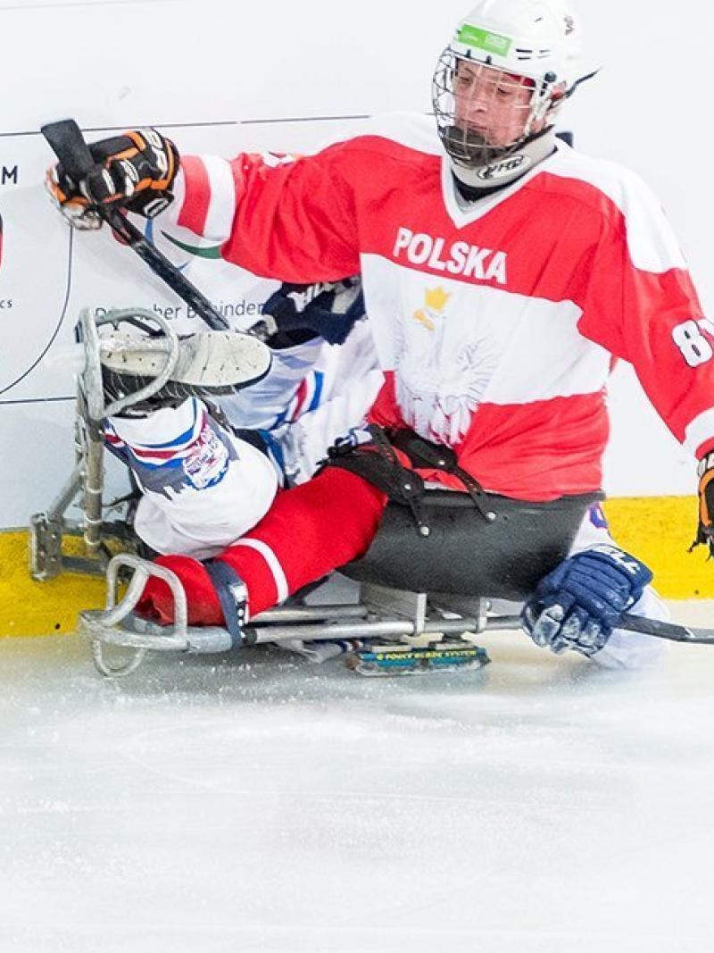 Para ice hockey player pushing another player to the fence