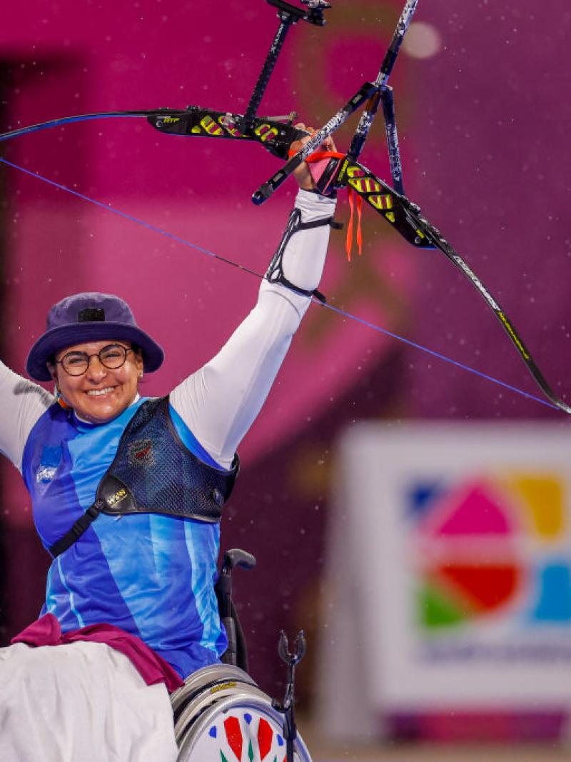Female archer raises arms in triumph