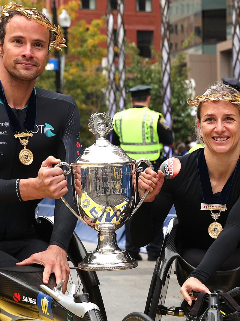 A man and woman pose with the trophy