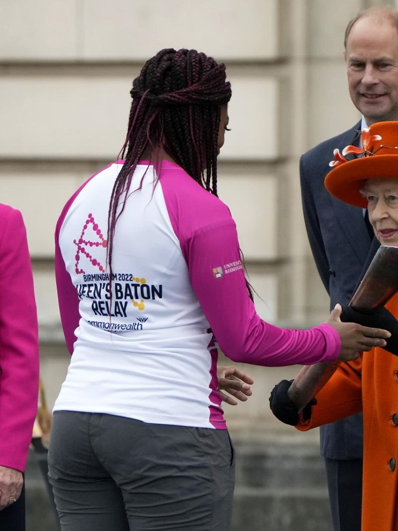Queen Elizabeth II hands over the Queen's Baton to the first relay runner Kadeena Cox