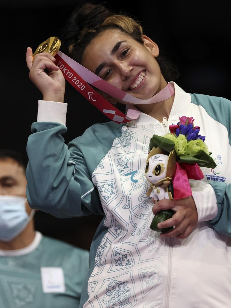 Guljonoy Naimova smiles as she celebrates with her gold medal