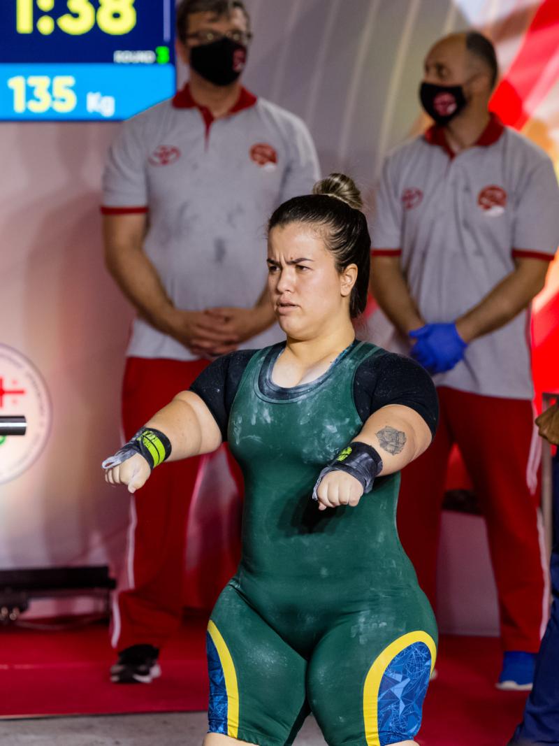 A woman preparing for her lift standing in front of the bar