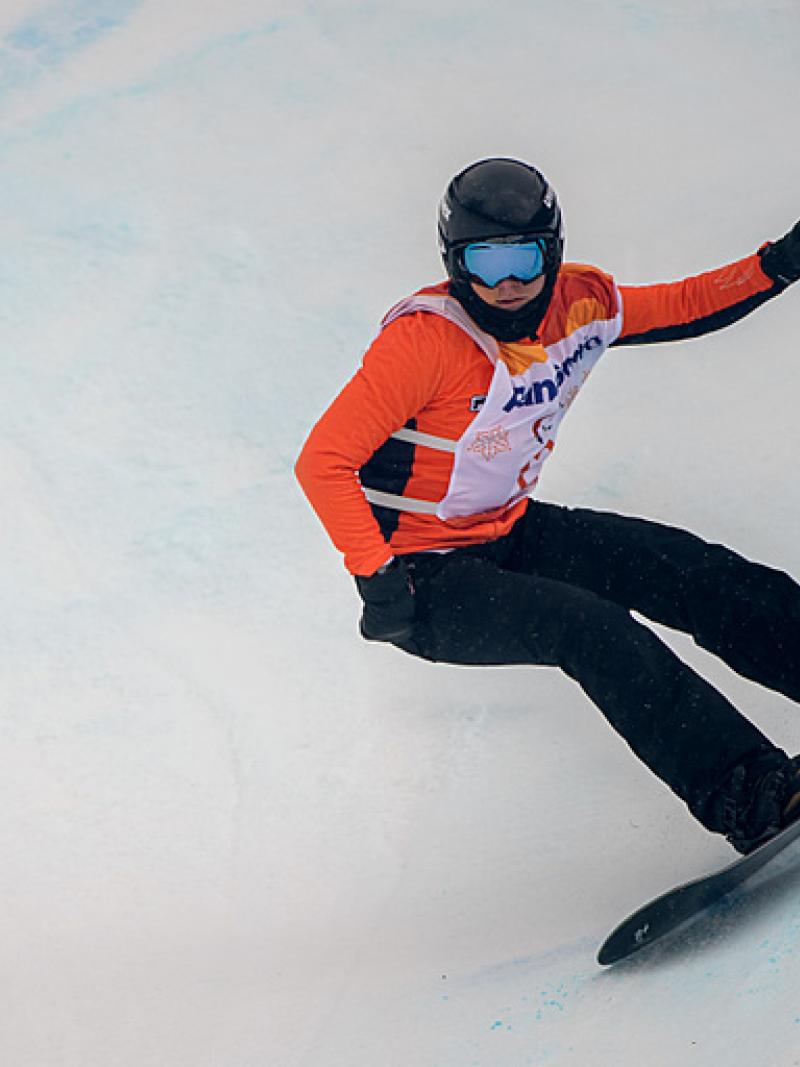 A female Para snowboarder riding with in a competition