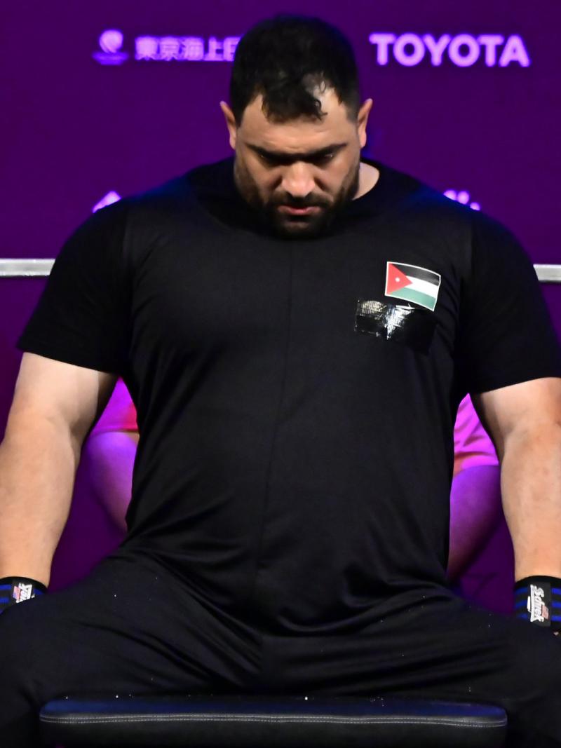A man sitting on the bench with his head down in concentration.