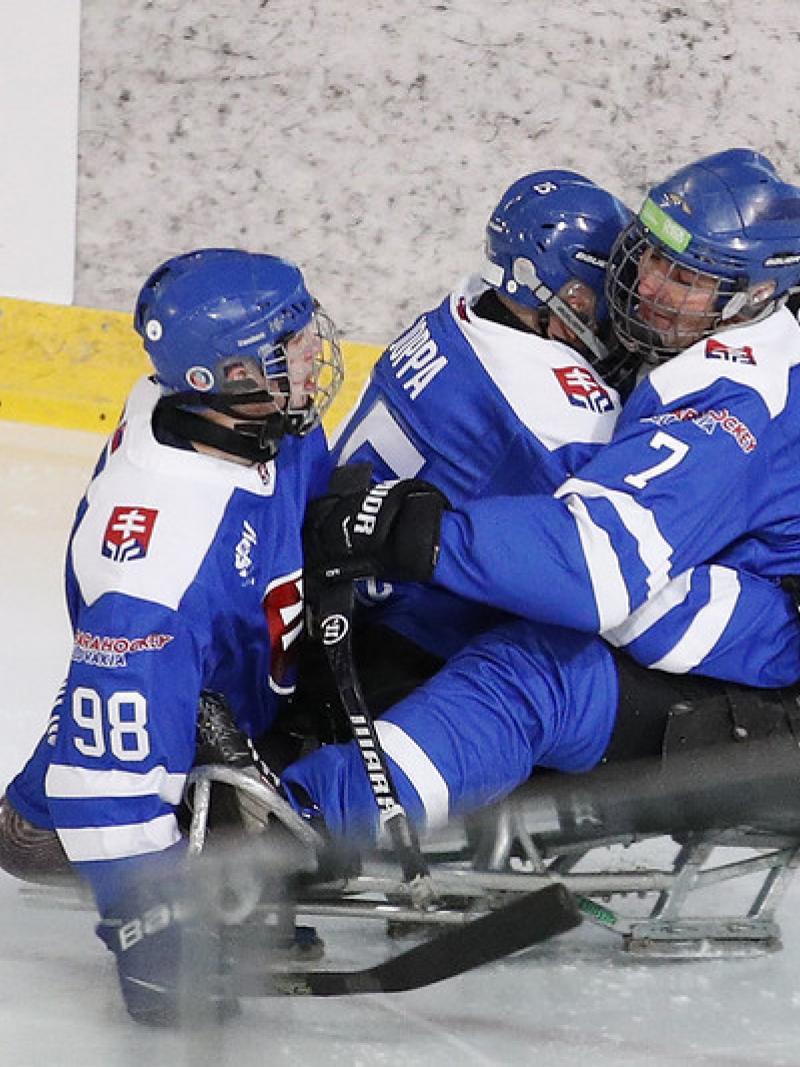 Three Para ice hockey players with Slovakia uniform celebrating