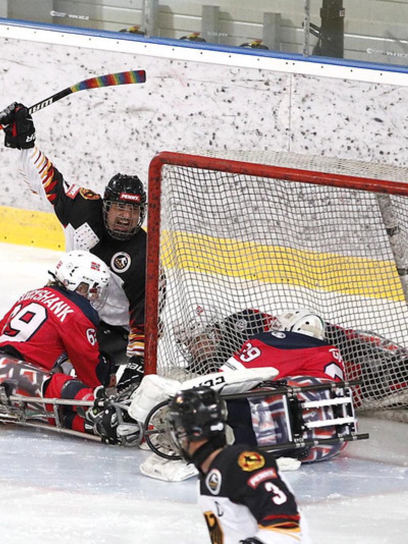 Three German and three Norwegian Para ice hockey players in a game