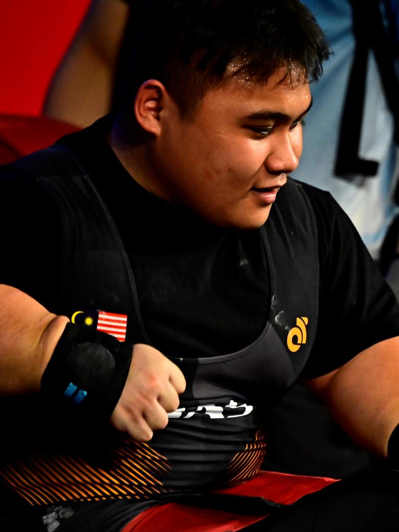 A man sitting on the bench after lifting the bar.