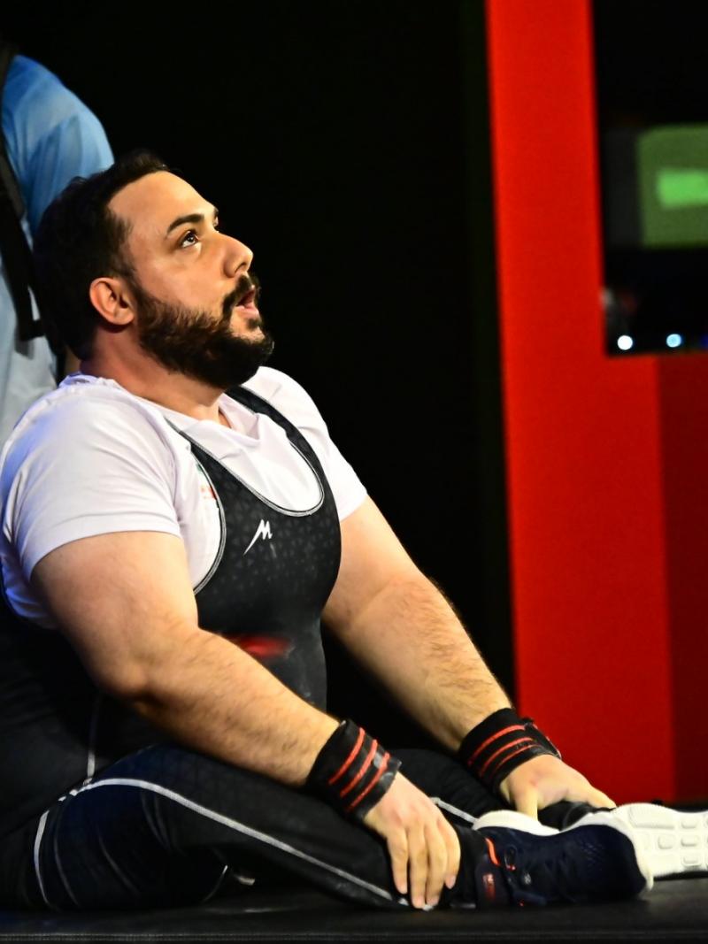 A man sitting on the bench and looking upwards.