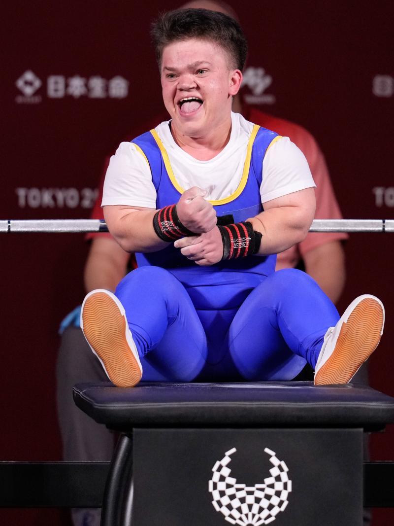 A woman sitting on the bench and smiling.