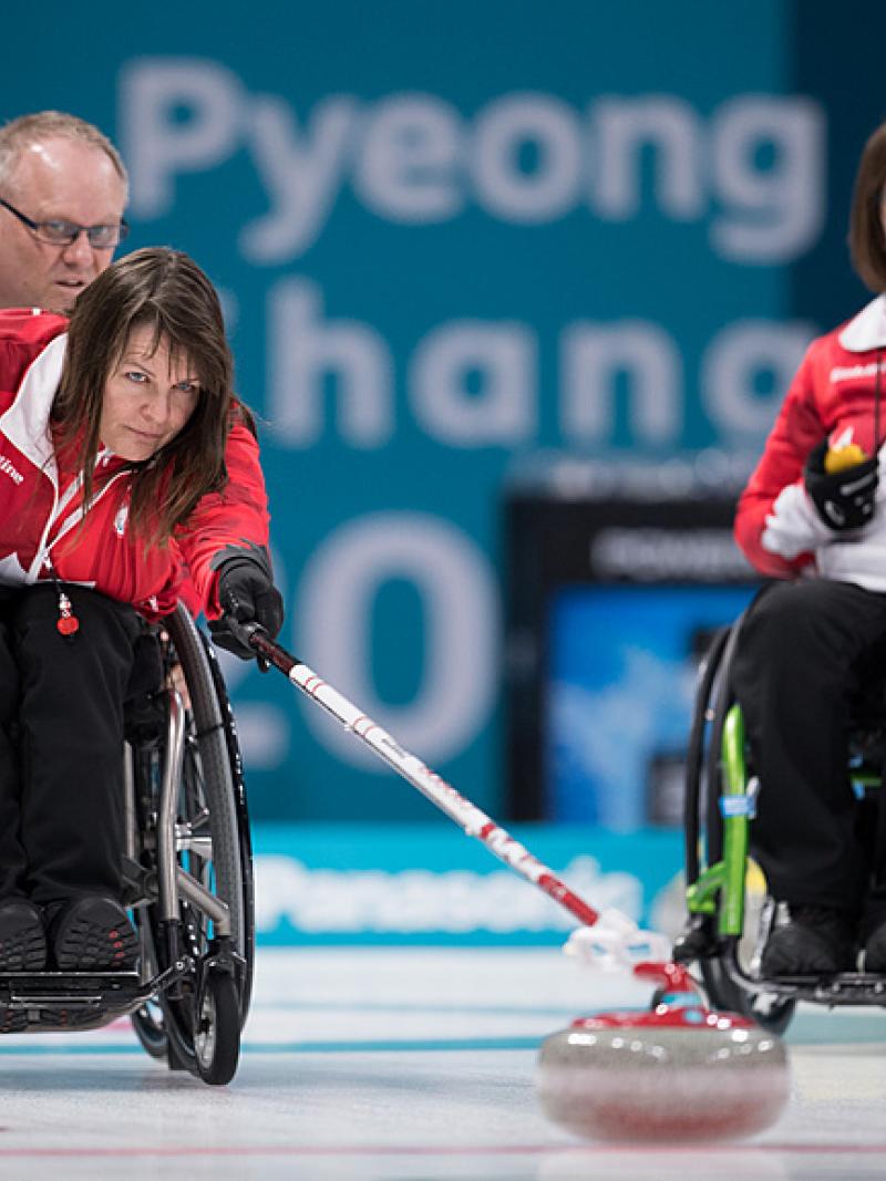 Canadian wheelchair curler Ina Forrest pushes the stone on the ice rink