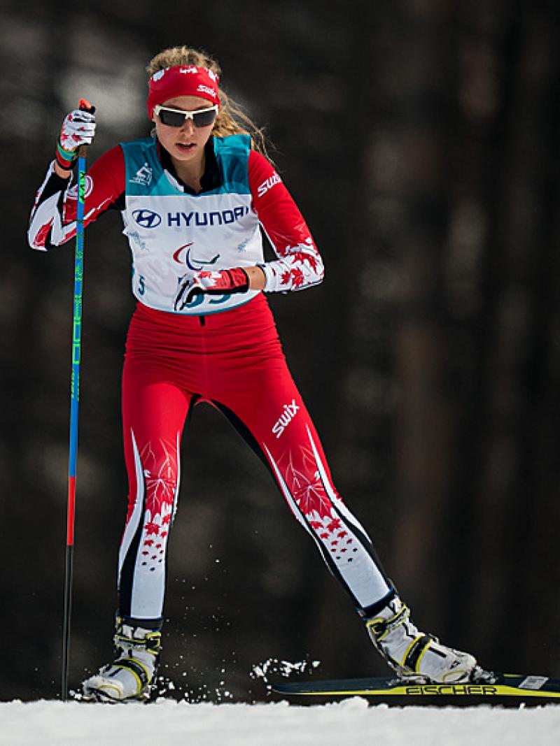 A standing woman competing in Para cross-country skiing