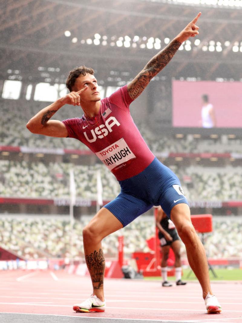 An athlete pointing towards the sky with his both hands in celebration.