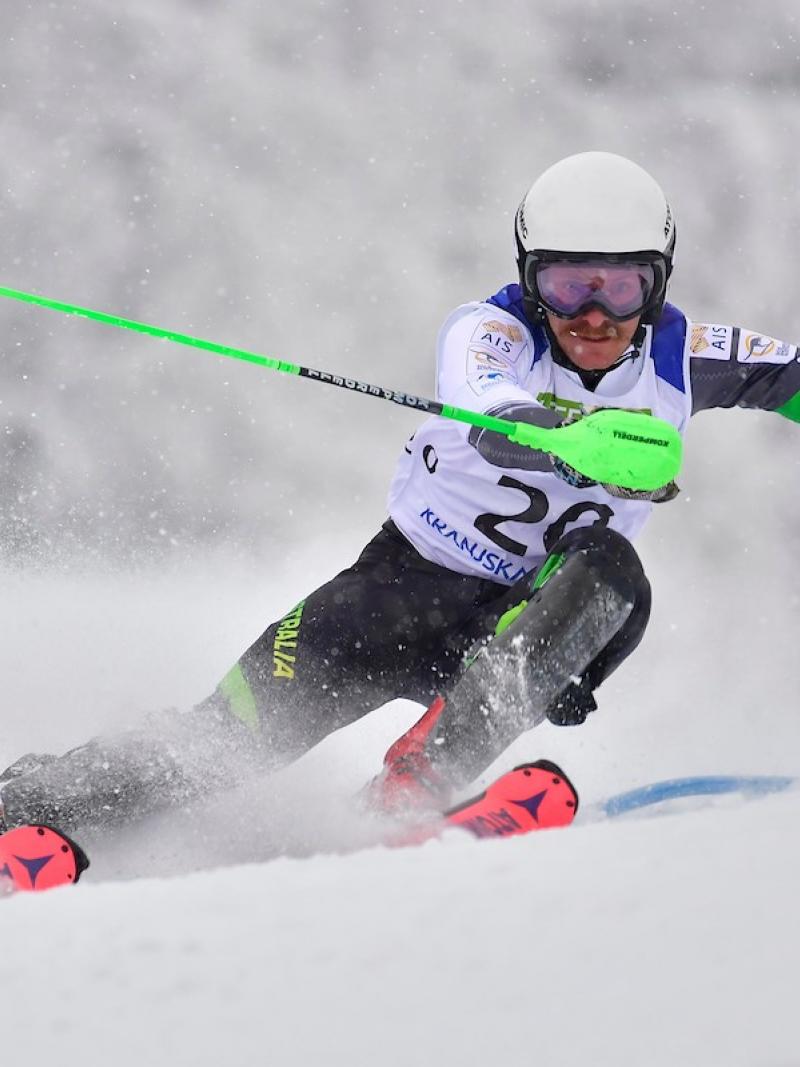 A man without an arm skiing in a Para alpine skiing competition