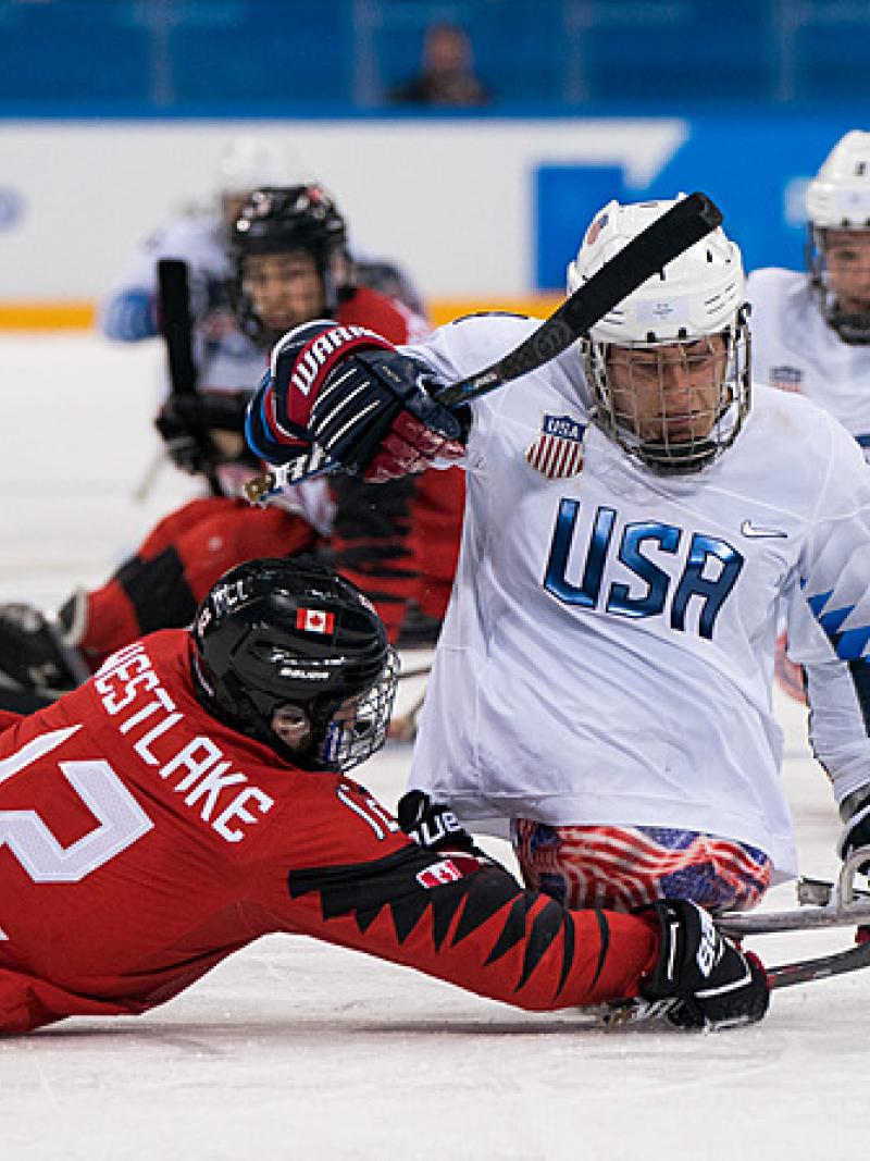 A Canadian Para ice hockey player challenging an USA player 