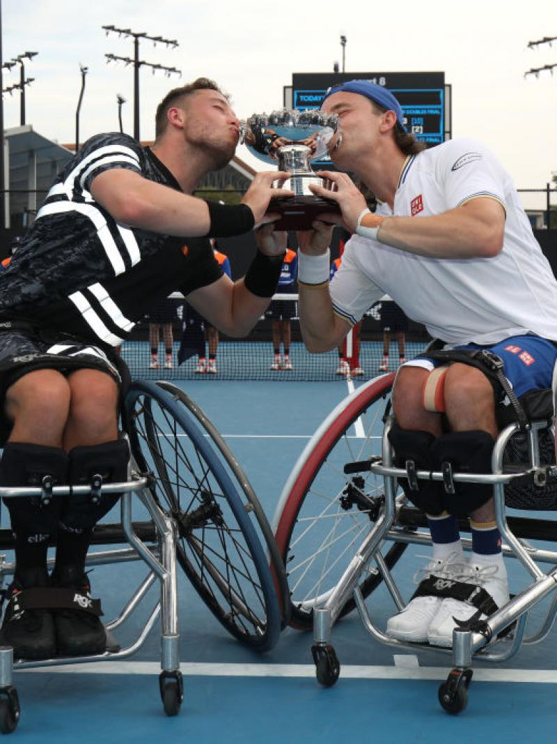 Alfie Hewett and Gordon Reid of Great Britain kiss the trophy after their victory in the men's Wheelchair Doubles final against Gustavo Fernandez of Argentina and Shingo Kunieda of Japan at the Australian Open.