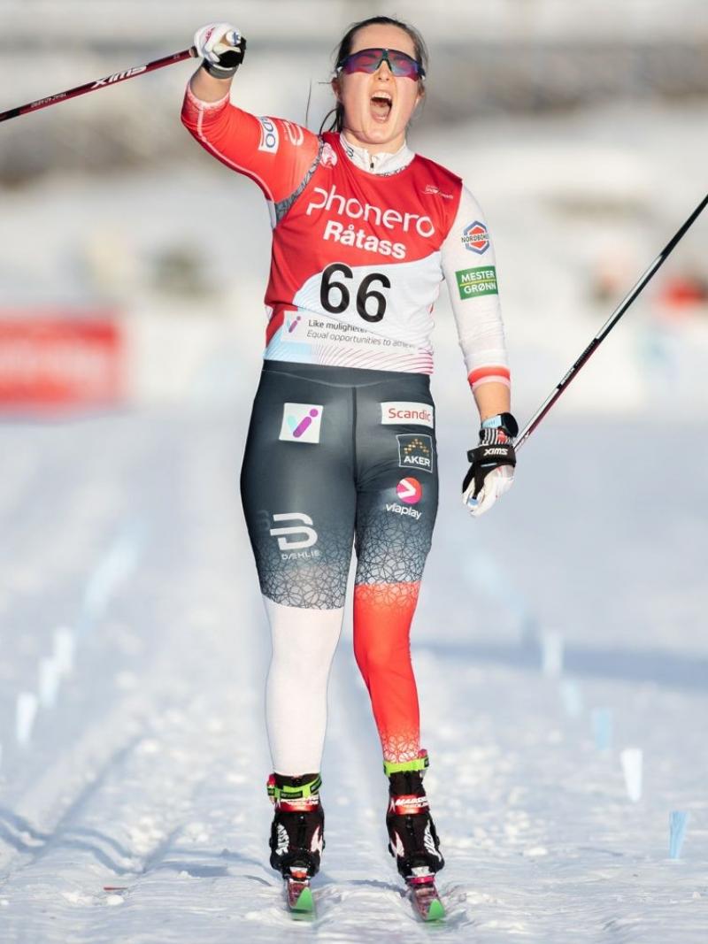 A female skier celebrating on a cross-country track