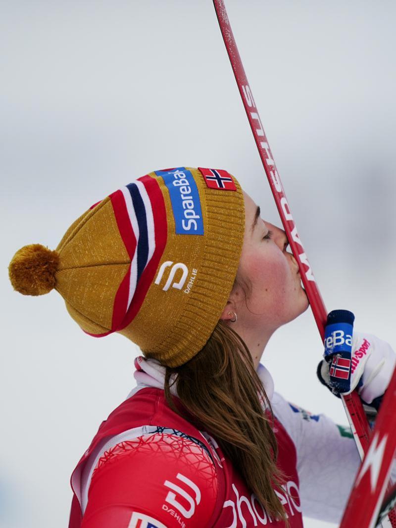 A female skier kissing her skis 