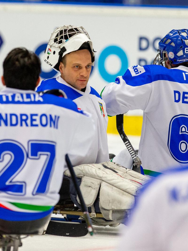 A goalie congratulated by his teammates on the ice