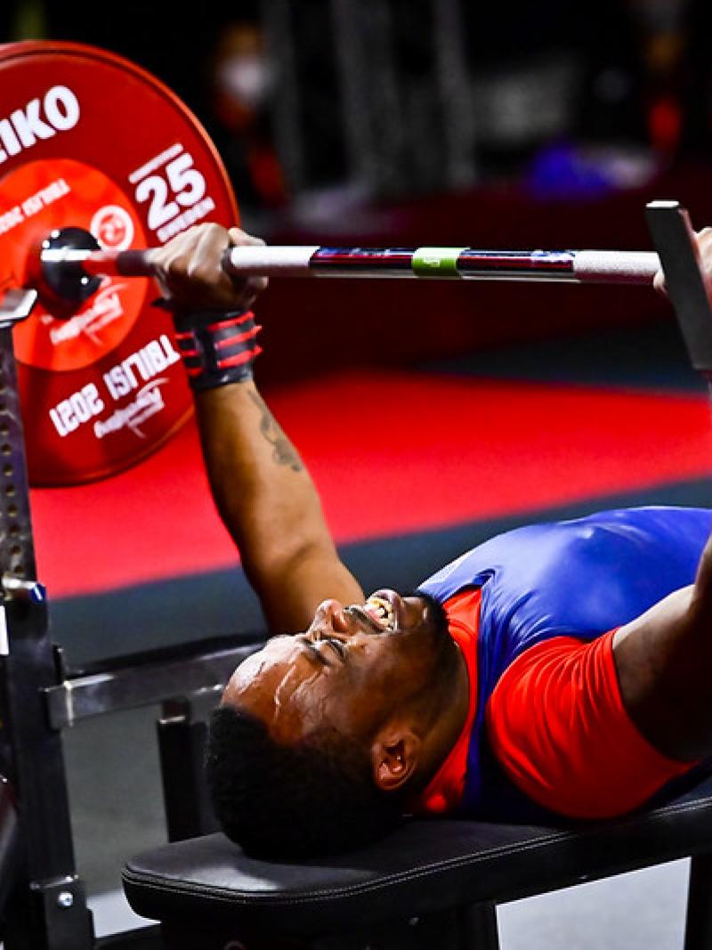A man lifting a bar on a bench press