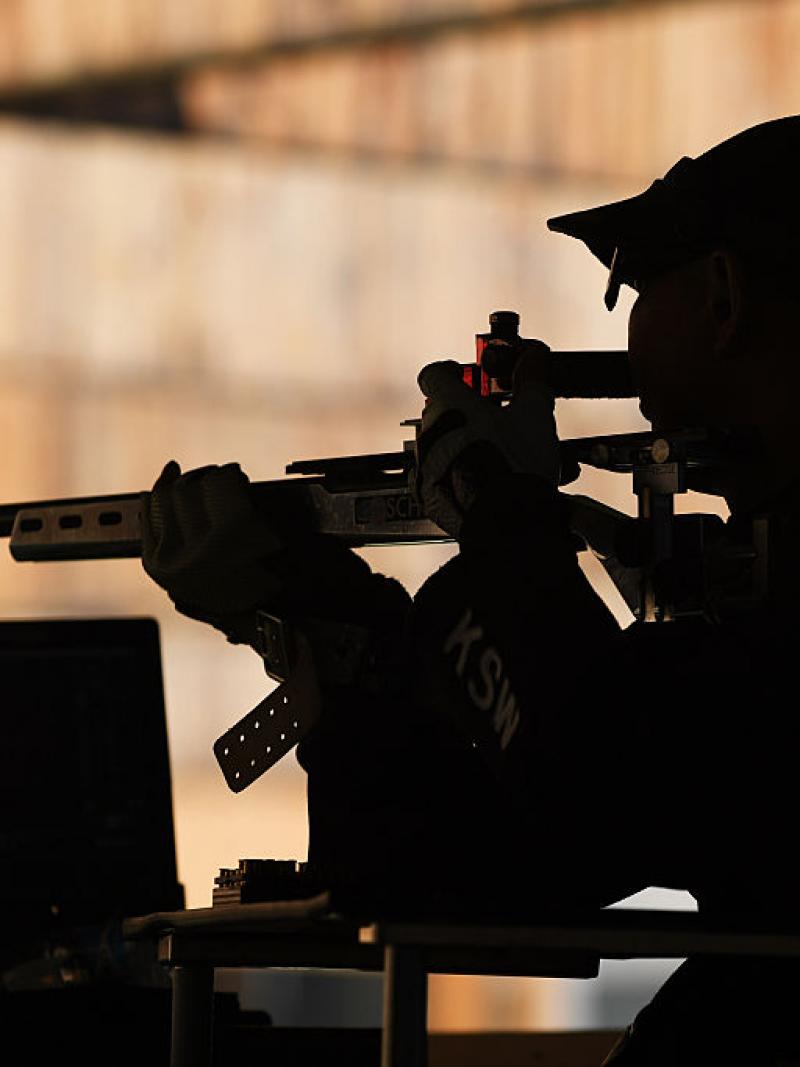 A male shooter with a rifle in a shooting range
