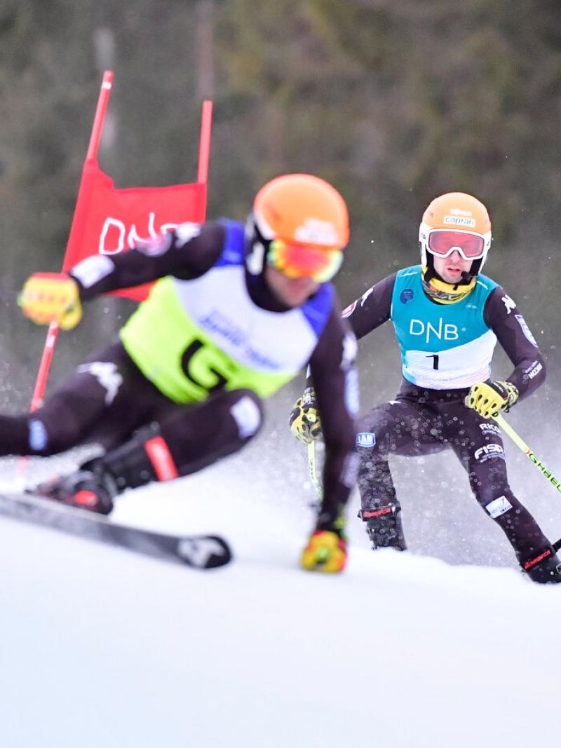 A man skiing with a microphone behind his guide.