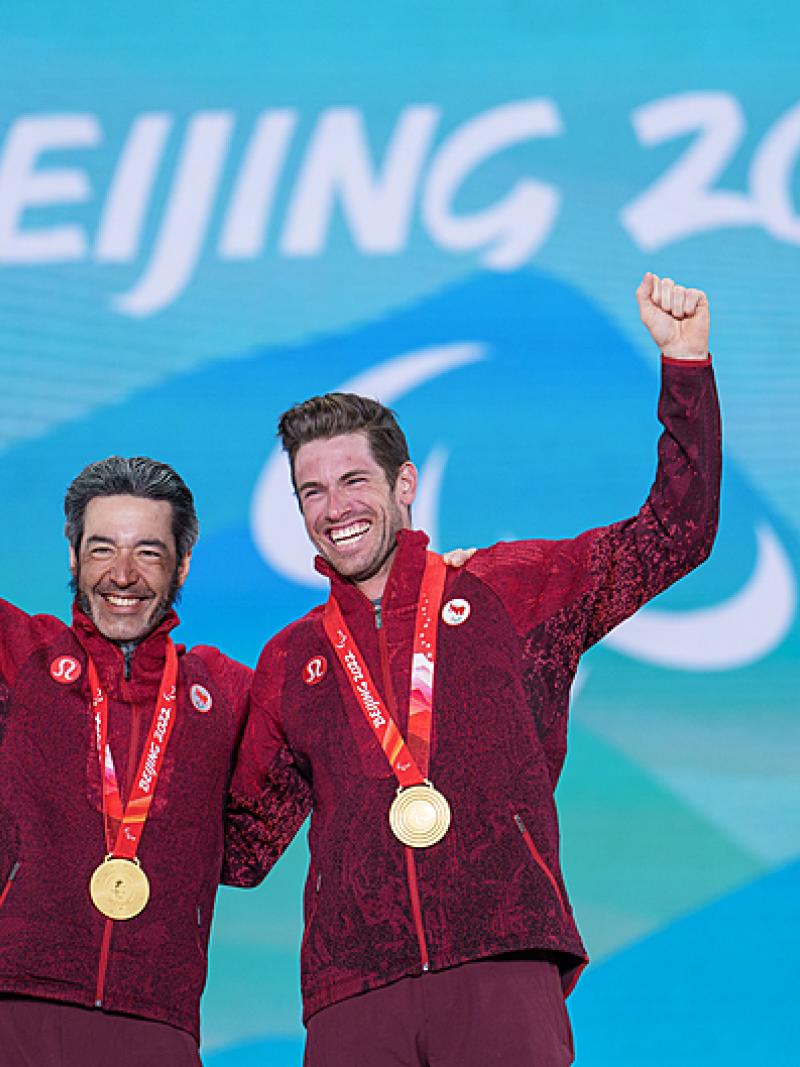 Brian Brian McKeever and Guide Graham Kennedy smile and wave after receiving their gold medals at Beijing 2022