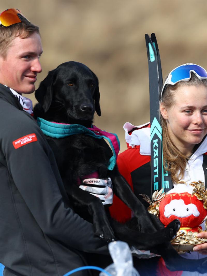 Gold medallist Carina Edlinger of Austria looks on with her guide dog Riley following the Women's Sprint Free Technique Vision Impaired Final flower ceremony in the Beijing 2022 Paralympic Winter Games at Zhangjiakou National Biathlon Centre. 