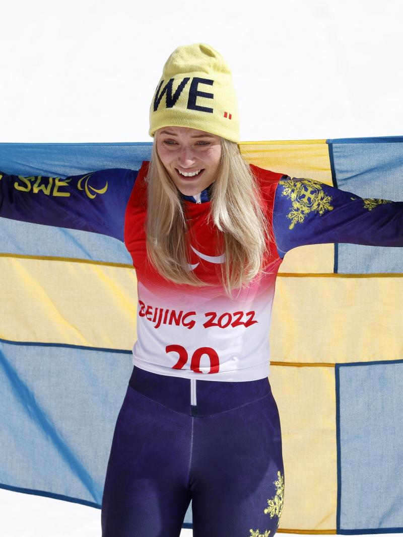 Ebba Aarsjoe celebrates with Swedish flag after winning her second gold at Beijing 2022